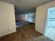 Spacious living room flows into adjacent kitchen with white cabinets and appliances at 4154 Versailles Dr # 4154D, Orlando, FL 32808