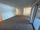 Inviting living room featuring neutral carpet, access to a patio, and seamless flow into other spaces at 4154 Versailles Dr # 4154D, Orlando, FL 32808