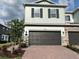 Two-car garage with a brick paver driveway and stone facade accents create curb appeal at 4315 Campsite Loop, Orlando, FL 32824