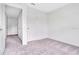 A carpeted bedroom with neutral walls and an open door leading to another room at 509 Madison Dr, Davenport, FL 33837