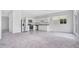 Well-lit kitchen with stainless steel appliances, white cabinets, and a view into the carpeted living area at 509 Madison Dr, Davenport, FL 33837