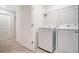 Bright laundry room with a modern, front-loading washer and dryer and a wire shelf above at 509 Madison Dr, Davenport, FL 33837