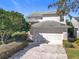 Charming two-story home featuring a two car garage and well maintained landscaping under a clear blue sky at 554 Queensbridge Dr, Lake Mary, FL 32746