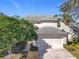 Exterior shot of a home featuring a two-car garage and mature landscaping at 554 Queensbridge Dr, Lake Mary, FL 32746