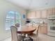 Charming kitchen with a round wooden dining table and chairs under a large arched window at 554 Queensbridge Dr, Lake Mary, FL 32746