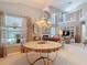 Spacious living room with a chandelier, large windows, and a clear view of the fireplace and upstairs balcony at 554 Queensbridge Dr, Lake Mary, FL 32746