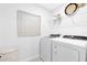 Neat laundry area featuring a washer, dryer, wire shelving, and tasteful decor at 6394 Tabebuia Pkwy, Winter Garden, FL 34787