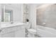 Modern bathroom features tiled backsplash, light gray tile flooring, and white cabinets at 6424 Tabebuia Pkwy, Winter Garden, FL 34787