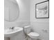 Charming half bathroom features a round mirror, pedestal sink, and wainscotting at 6424 Tabebuia Pkwy, Winter Garden, FL 34787