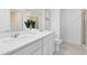 Bright bathroom features double sinks, white cabinets, quartz countertops, and tiled floors at 6424 Tabebuia Pkwy, Winter Garden, FL 34787