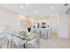 Bright dining room with a glass table set, modern lighting fixtures, and adjacent kitchen view at 6424 Tabebuia Pkwy, Winter Garden, FL 34787