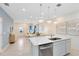 Open-concept kitchen with stainless steel appliances, quartz counters, and pendant lighting overlooking living space at 6424 Tabebuia Pkwy, Winter Garden, FL 34787