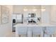 Kitchen boasts stainless appliances, white cabinetry, quartz countertops, and stylish pendant lighting at 6424 Tabebuia Pkwy, Winter Garden, FL 34787