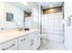 Clean bathroom with a single vanity, and a shower-tub combo with a colorful curtain at 7464 Gathering Dr, Reunion, FL 34747