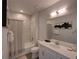 Contemporary bathroom with a shower-tub, a single vanity, and stylish mirror at 7464 Gathering Dr, Reunion, FL 34747