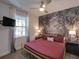 Cozy bedroom with a gold bed frame, unique wallpaper, and soft lighting fixtures at 7464 Gathering Dr, Reunion, FL 34747