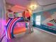 Delightful space themed bedroom with a custom bunk bed and colorful neon lights at 7464 Gathering Dr, Reunion, FL 34747