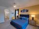 Bright bedroom with a blue bed, side tables, and decor with an ensuite bathroom at 7464 Gathering Dr, Reunion, FL 34747