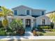Beautiful two-story home with a lush landscaped yard and welcoming front porch at 7464 Gathering Dr, Reunion, FL 34747