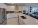 Modern kitchen featuring stainless steel appliances, white cabinetry and a large center island at 7464 Gathering Dr, Reunion, FL 34747