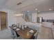 Modern kitchen featuring an island with seating, stainless steel appliances, and an open dining space at 7464 Gathering Dr, Reunion, FL 34747
