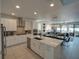 Modern kitchen featuring white cabinets, quartz countertops, stainless steel appliances, and open living area at 7464 Gathering Dr, Reunion, FL 34747