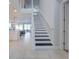 Contemporary staircase with black treads and white risers leads to the upper level at 7464 Gathering Dr, Reunion, FL 34747