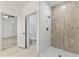 Modern bathroom boasts a walk-in shower with white and textured grey accent tile and a neutral tile floor at 8015 Sw 133Rd Ln, Ocala, FL 34473