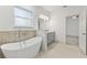 Stylish bathroom with a freestanding tub, gray vanity, and modern fixtures at 8015 Sw 133Rd Ln, Ocala, FL 34473