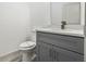 Modern half-bathroom with gray vanity, granite countertop, and new toilet at 8015 Sw 133Rd Ln, Ocala, FL 34473