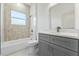 Bathroom featuring a shower-tub combo with a grey vanity, white countertop, and a window above the tub at 8015 Sw 133Rd Ln, Ocala, FL 34473