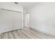 Bedroom featuring a closet with bi-fold doors, light grey laminate flooring and white walls at 8015 Sw 133Rd Ln, Ocala, FL 34473