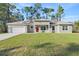 Charming single-story home with a well-manicured lawn and a bright red front door at 8015 Sw 133Rd Ln, Ocala, FL 34473