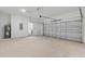Spacious two-car garage with white block walls and a door that leads to the inside of the home at 8015 Sw 133Rd Ln, Ocala, FL 34473
