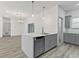 Open-concept kitchen with island, gray cabinets, and modern stainless steel dishwasher at 8015 Sw 133Rd Ln, Ocala, FL 34473