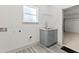 Laundry room boasts a utility sink and a window for natural light, laminate floors and a door to the garage at 8015 Sw 133Rd Ln, Ocala, FL 34473
