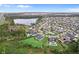 Expansive aerial view of a neighborhood with a beautiful pond, lush green trees, and stunning homes at 8614 Hata St, Orlando, FL 32827