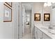Bright bathroom featuring a white vanity with quartz countertop and hallway access at 8614 Hata St, Orlando, FL 32827
