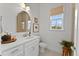 Well-lit bathroom featuring a vanity, window, and a shower at 8614 Hata St, Orlando, FL 32827