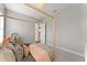 Bedroom with a four-poster bed, neutral decor, and hallway access at 8614 Hata St, Orlando, FL 32827