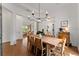 Bright dining room featuring a modern chandelier, hardwood floors, and an open view to the living area at 8614 Hata St, Orlando, FL 32827