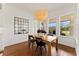 Dining room features a pendant light fixture, large windows, hardwood floors, and a modern mirror at 8614 Hata St, Orlando, FL 32827