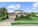 Charming exterior elevation of a beautiful home featuring a manicured lawn, mature palm tree, and a brick driveway at 8614 Hata St, Orlando, FL 32827
