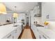 Open kitchen features white cabinetry, quartz countertops, stainless steel appliances, and hardwood floors at 8614 Hata St, Orlando, FL 32827