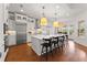 Bright, modern kitchen featuring stainless steel appliances, a large island, pendant lights, and hardwood floors at 8614 Hata St, Orlando, FL 32827