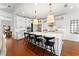 Bright kitchen boasts white cabinets, stainless appliances, large island with seating and hardwood floors at 8614 Hata St, Orlando, FL 32827
