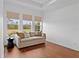 Bright living room with a comfortable sofa, hardwood floors, and three large windows at 8614 Hata St, Orlando, FL 32827