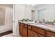 Bathroom boasts dual sinks with granite countertops and a shower with a curtain at 8879 Geneve Ct, Kissimmee, FL 34747
