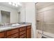 Bathroom featuring double sinks with granite countertops and a glass-enclosed shower at 8879 Geneve Ct, Kissimmee, FL 34747