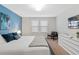 Comfortable bedroom featuring a large bed, neutral decor, and bright natural light from the window at 8879 Geneve Ct, Kissimmee, FL 34747